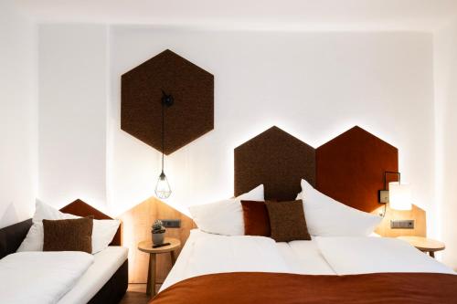 two beds in a bedroom with white walls at Hotel Trattnig in Döbriach