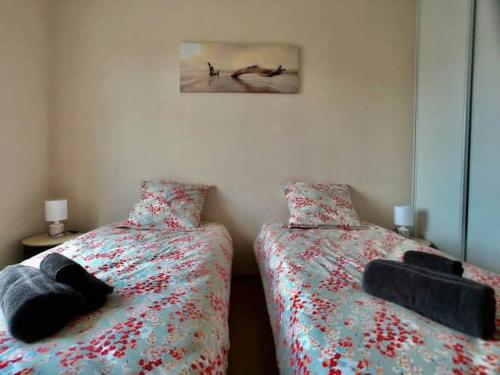 a bedroom with two beds and a picture on the wall at Normandy Confort - WIFI & CALM - Bayeux Centre in Bayeux