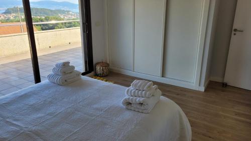 a room with a bed with towels on it at Casa con piscina Sanxenxo in Pontevedra