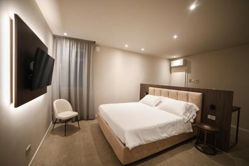 a bedroom with a bed and a tv and a chair at Modena Relax Luxury Rent Rooms in Modena