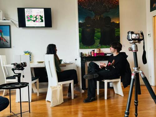 un homme assis dans une pièce avec caméra dans l'établissement Artist Rooms Paris, à Paris