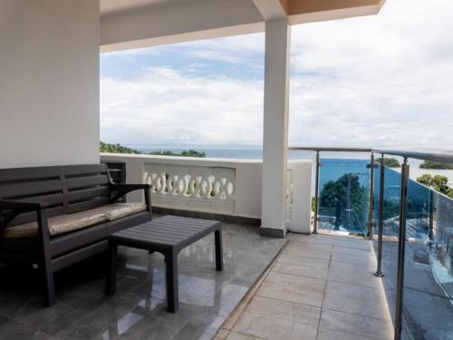 a balcony with a bench and a view of the ocean at Villas Hillside apt 4 in Santa Bárbara de Samaná