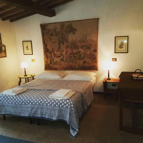 a bedroom with a bed with a painting on the wall at Casa Vacanze Le Corone in Otricoli