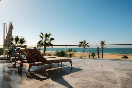 a couple of chairs sitting on a patio with the beach at Hyatt Regency Taghazout in Taghazout