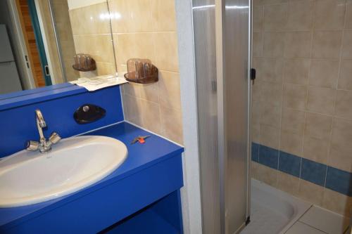 La salle de bains bleue est pourvue d'un lavabo et d'une douche. dans l'établissement Studio mezzanine 4 couchages ARGELES SUR MER AR580-268, à Argelès-sur-Mer