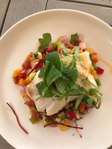 a white plate with a salad with chicken and vegetables at Casa Di fiore in Maubourguet