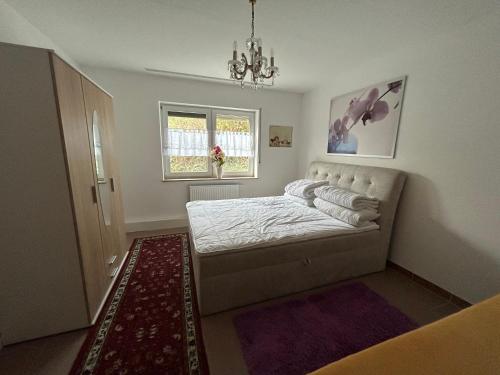a bedroom with a bed and a window at Nicoles Niedschlösschen in Rehlingen-Siersburg