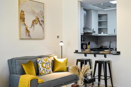 a living room with a couch and a kitchen at Modern Studio in Discovery Gardens, Close to Metro in Dubai