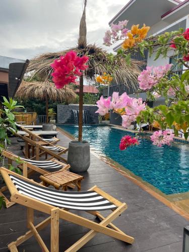 a group of lounge chairs next to a swimming pool at Lanta Corsica Hotel in Ko Lanta