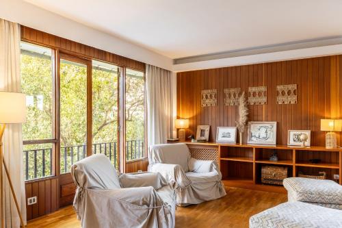 Zimmer mit zwei weißen Stühlen und Fenstern in der Unterkunft Villa Palma in Palma de Mallorca