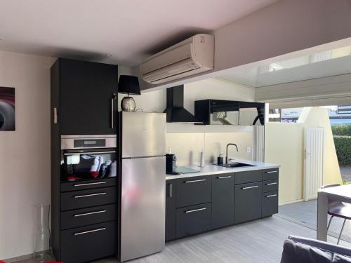 La cuisine est équipée d'un réfrigérateur et d'un évier. dans l'établissement Village Naturiste Villa luxe Port Nature 1, au Cap d'Agde