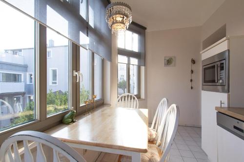a dining room with a table and some windows at 5 Meereslust in Rostock