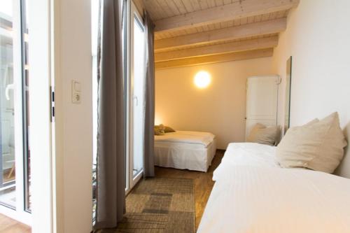 a bedroom with two beds and a large window at Skipperlodge - Versteck am Strom in Warnemünde