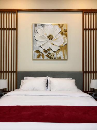 a bedroom with a white flower painting on the wall at Van Bloemen 1881 Resort in Kembanglimus
