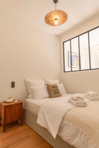 une chambre blanche avec un lit et une fenêtre dans l'établissement Hyper Centre, balcon, 5min de la plage, AC, à Nice