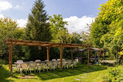 a group of tables and chairs in a garden at Villa des glycines et Spa in Cempuis