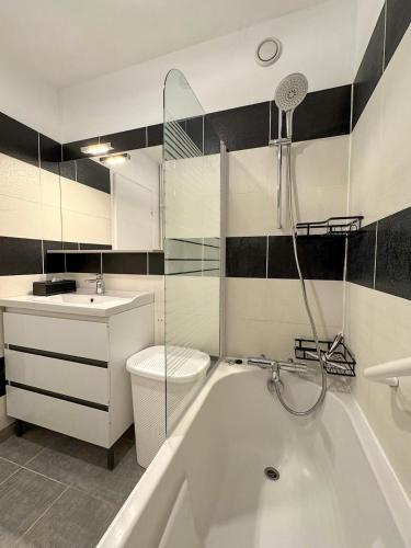 une salle de bain avec une baignoire, des toilettes et un lavabo dans l'établissement Villa Bel Air - appartement avec jardin et parking, à Chartres