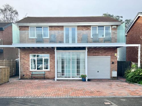a brick house with a white garage at 4 Bed Retreat with Balcony & Estuary views in Exeter