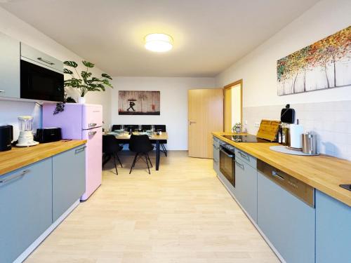 a large kitchen with blue cabinets and a table at Ferienwohnung Himmelslicht in Frohse