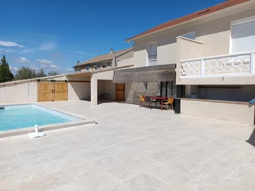 une grande arrière-cour avec une piscine et une maison dans l'établissement Maison cœur de village piscine 6 personnes, à Vacqueyras