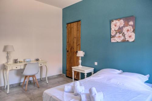 une chambre avec un lit, une table et un bureau dans l'établissement Maison cœur de village piscine 6 personnes, à Vacqueyras