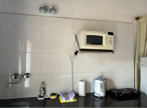 un forno a microonde su uno scaffale sopra il bancone della cucina di Complejo San Cristobal a Santa Clara del Mar