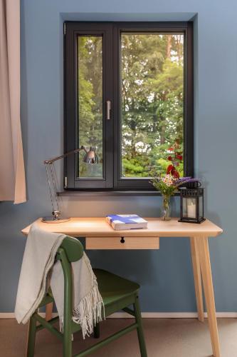 a wooden desk with a window and a green chair at Ferienhaus direkt am See Uckermark in Templin
