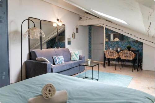 Un dormitorio con una cama, un sofá y una mesa. en Lafayette Bohème chic, en Lyon