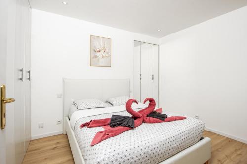 - une chambre avec un lit doté d'un ruban rouge dans l'établissement VILLA FLORENTINE I - Frontière Monaco - Agréable deux pièces - PARKING, à Beausoleil