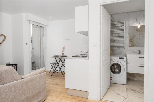 une cuisine blanche avec un évier et une machine à laver dans l'établissement VILLA FLORENTINE I - Frontière Monaco - Agréable deux pièces - PARKING, à Beausoleil