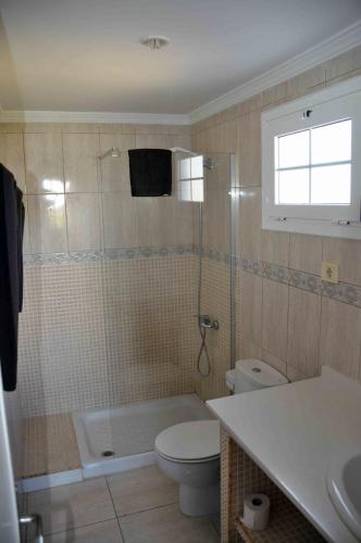a bathroom with a shower and a toilet and a sink at Bungalows Los Arcos in Playa del Ingles