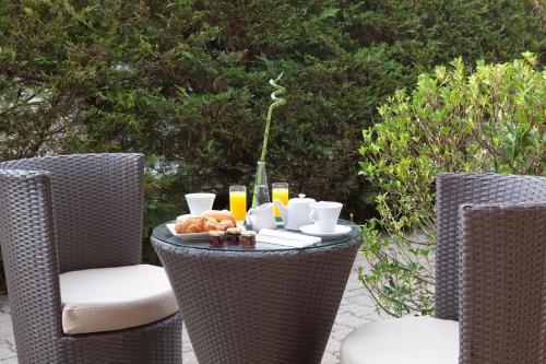 una mesa al aire libre con una bandeja de comida y bebida en Contact Hôtels Les Pierres Dorées, en Ambérieux d'Azergues