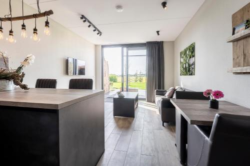 a kitchen and dining room with a table and chairs at Appartementen De Wilg - Adults only in Noordwijk aan Zee
