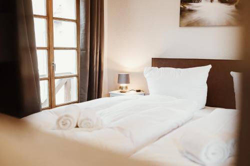 a white bed with two towels on it with a window at Gutshof zu Quedlinburg in Quedlinburg