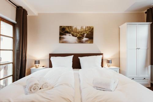 a bedroom with a white bed with towels on it at Gutshof zu Quedlinburg in Quedlinburg