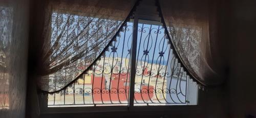 a window with a view of a building at Quiet spacious apartment in Larache