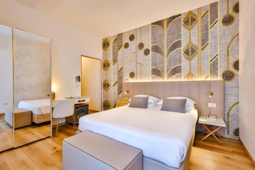 a hotel room with two beds and a mirror at UNAHOTELS Imperial Sport Hotel in Pesaro