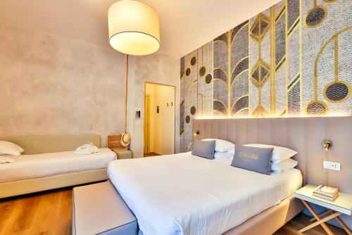 a hotel room with two beds and a couch at UNAHOTELS Imperial Sport Hotel in Pesaro