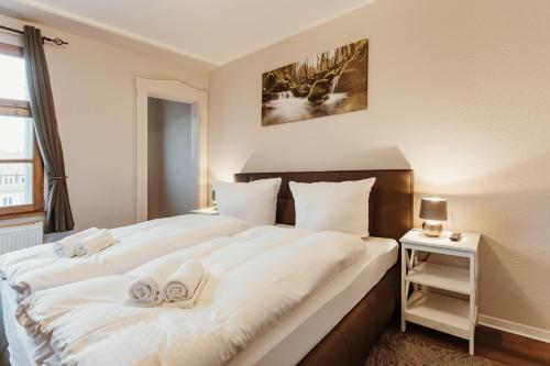 a bedroom with a large white bed with towels on it at Gutshof zu Quedlinburg in Quedlinburg