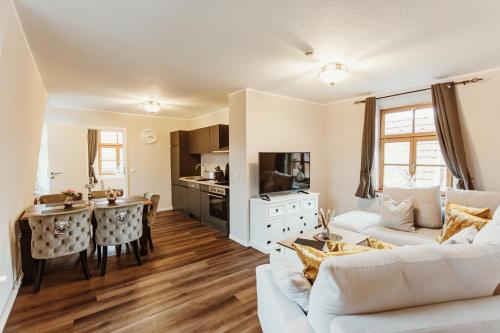 a living room with a white couch and a kitchen at Gutshof zu Quedlinburg in Quedlinburg