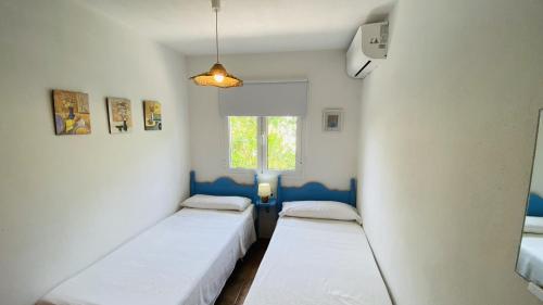a room with three beds in it with a window at Villa Cristina in Binibeca