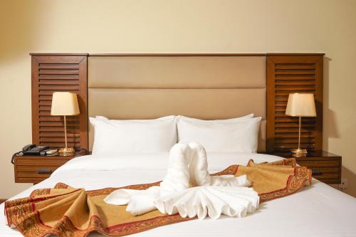 a bed with two towels and a robe on it at Faletti's Grand Hotel Gujranwala in Gujrānwāla