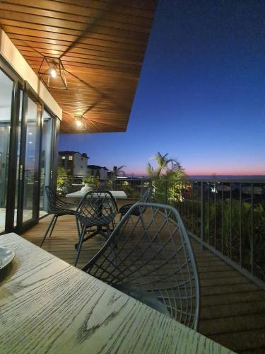 a balcony with a table and chairs and a view of the ocean at Entire Modern Apartment, Couples Sunset Getaway in Ballito