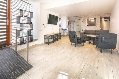 un salon avec un canapé, une table et des chaises dans l'établissement Le Refuge de Valdaine - Joli studio climatisé, à Merlas