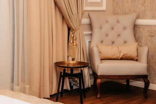 a chair and a table in a room at Golf du Rova Luxury Hotel in Antananarivo