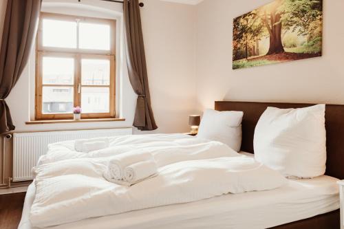 a bedroom with a large white bed with a window at Gutshof zu Quedlinburg in Quedlinburg