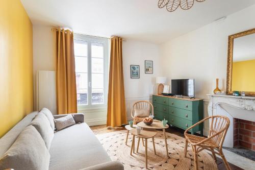 un salon avec un canapé et une cheminée dans l'établissement Le Soleil Malouin - Proche Parc de Bel-Air, à Saint-Malo