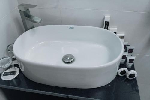 a white sink sitting on top of a counter in a bathroom at The Manor Hotel by Luckzi in Owerri