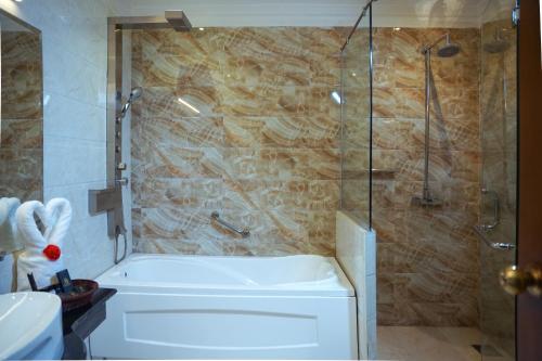 a bathroom with a shower and a tub and a sink at Faletti's Grand Hotel Gujranwala in Gujrānwāla