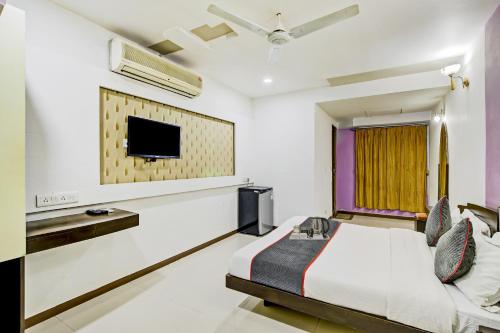 a bedroom with a bed and a tv on the wall at Collection O Riddhi Siddhi in Vadodara